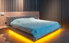 Modern bedroom with a bed and underfloor lighting